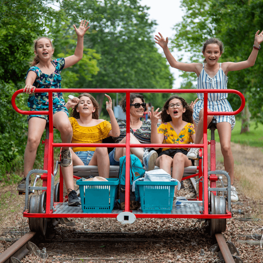 Que faire en Ardèche - famille avec enfants en train de faire du Vélorail sur d’anciennes voies ferrées