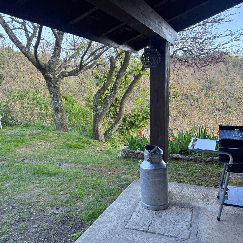 terrasse du gite pourette avec un barbecue et vue sur le jardin
