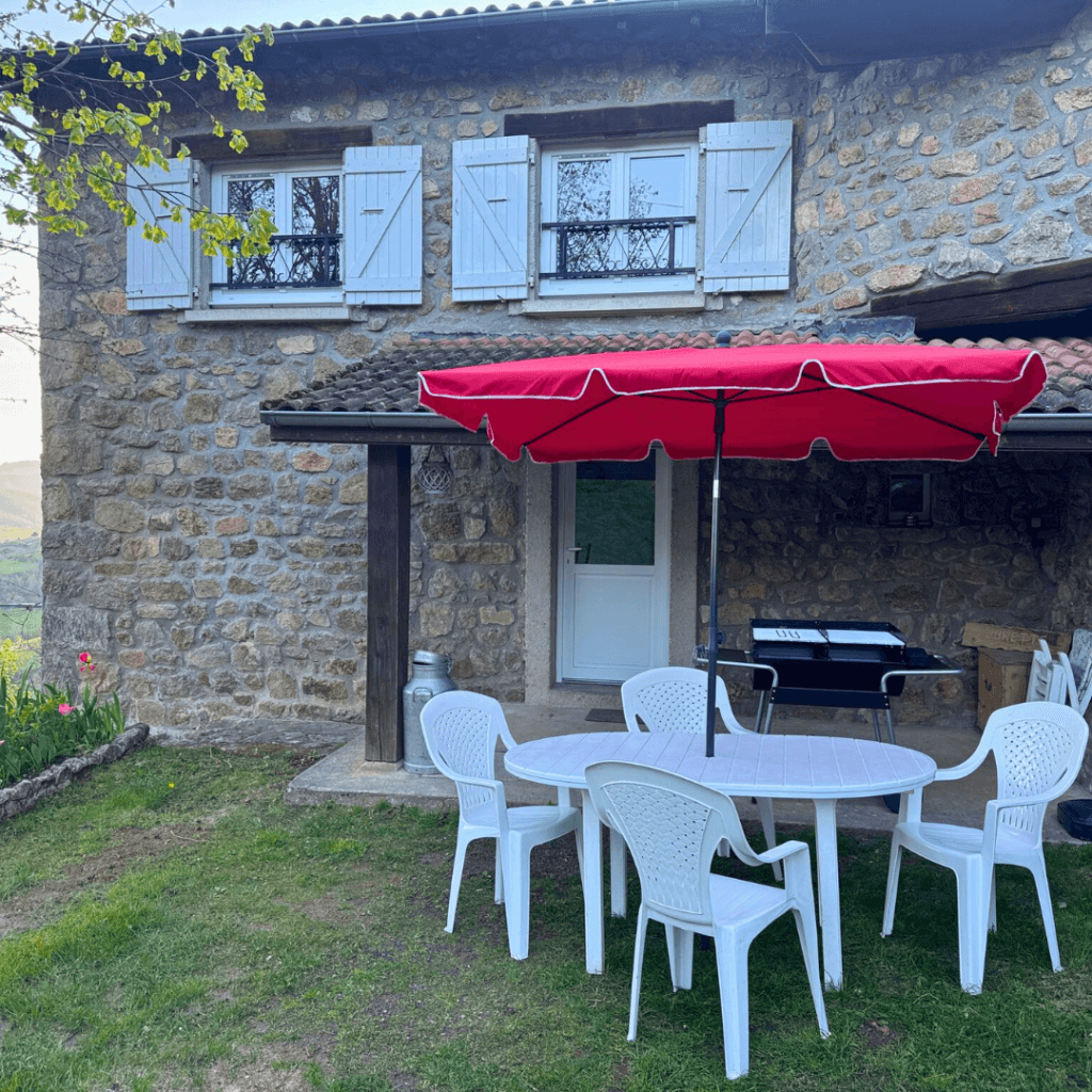 table et chaises de jardin avec parasol rouge du gite pourette