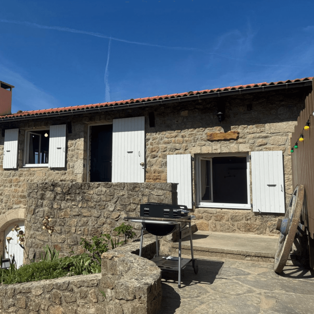 façade extérieure du gite la comballe, avec un barbecue sur l'esplanade
