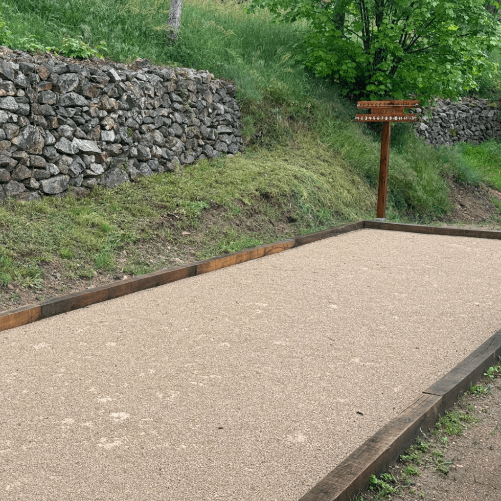 terrain de pétanque entouré de verdure