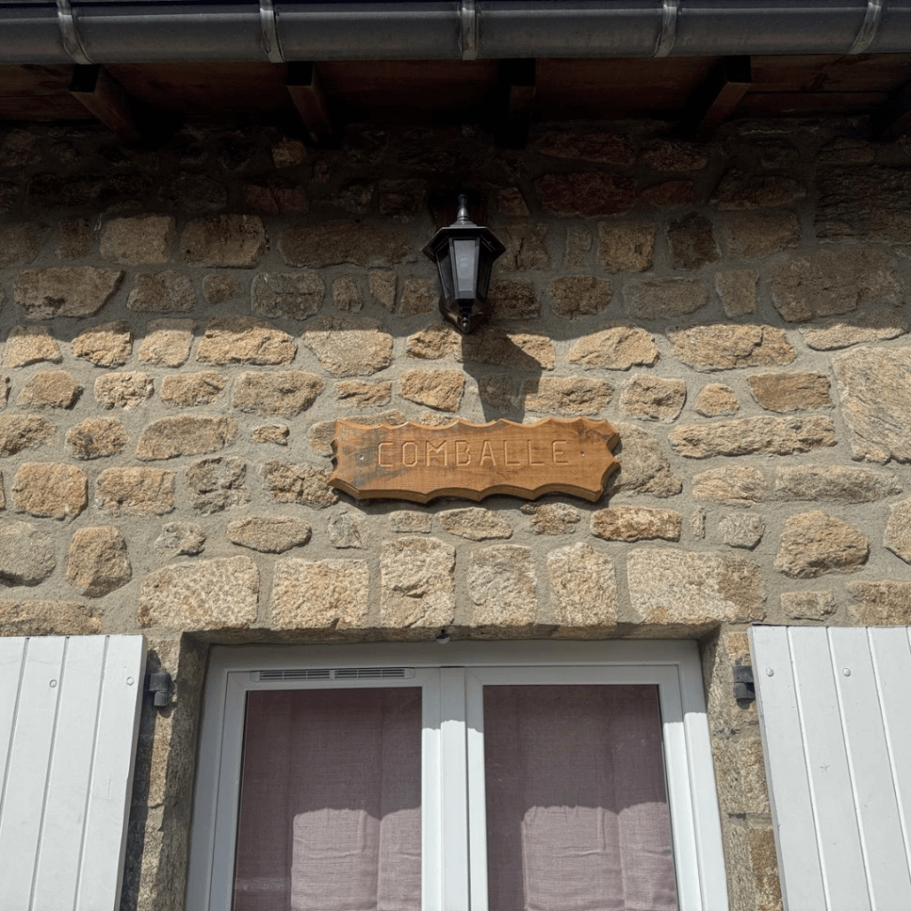 panneau en bois gravé la comballe au dessus de l'entrée des clients