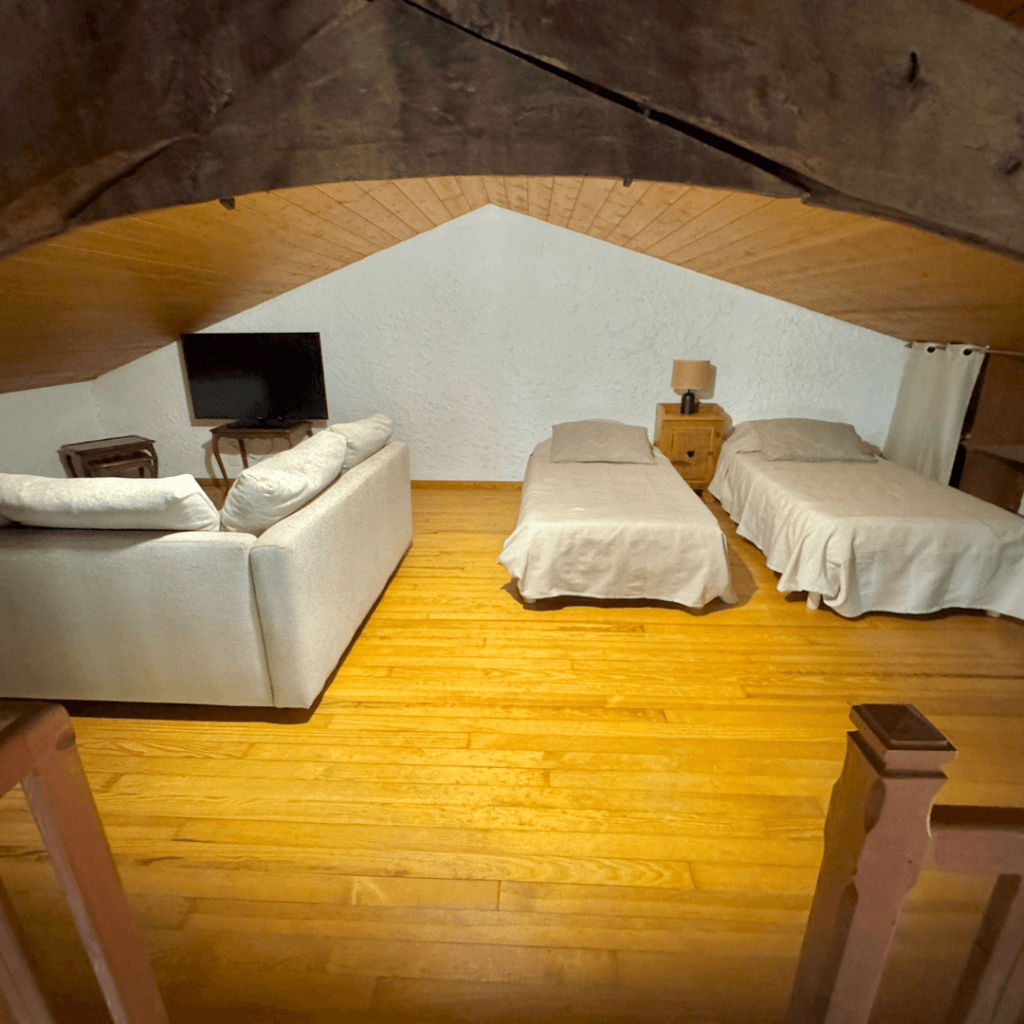 mezzanine du gite la comballe avec 2 lits simples et un canapé d'angle convertible et une tv